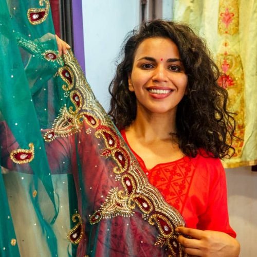 brunette indian woman choosing a new tradition saree in market.